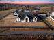 Expansive aerial view showcasing the modern farmhouse, surrounding landscape, and neighboring properties at 5180 Howard Rd, Cumming, GA 30040