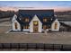 Luxury farmhouse exterior at dusk; two-story home with black roof and white siding at 5180 Howard Rd, Cumming, GA 30040