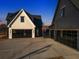 Modern farmhouse with two attached garages and a large concrete driveway at 5180 Howard Rd, Cumming, GA 30040