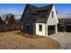 Beautiful modern farmhouse exterior with black siding and white accents, plus a glass-paneled garage door at 5180 Howard Rd, Cumming, GA 30040