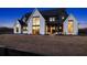 Luxury farmhouse exterior at dusk, showcasing a two-story home with black and white accents at 5180 Howard Rd, Cumming, GA 30040