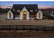 Luxury farmhouse with black roof and white siding at sunset at 5180 Howard Rd, Cumming, GA 30040