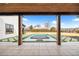 View from the covered patio to the square pool and spa surrounded by a lush green lawn at 5180 Howard Rd, Cumming, GA 30040