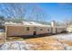 Back exterior view of brick home and yard with mature trees in winter at 3002 Arabian Woods Dr, Lithonia, GA 30038