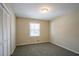 Neutral bedroom offers soft carpet, bright light, and closet with bi-fold doors at 3002 Arabian Woods Dr, Lithonia, GA 30038