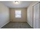 Cozy bedroom features neutral carpet, closet with bi-fold doors, and a window at 3002 Arabian Woods Dr, Lithonia, GA 30038
