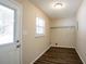 Bright laundry room boasts wood floors, large window, and convenient shelving at 3002 Arabian Woods Dr, Lithonia, GA 30038