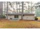 A single-story home with a backyard patio and grassy area surrounded by trees at 2405 County Line Sw Rd, Atlanta, GA 30331