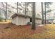 The backyard of a home featuring a small patio and a grassy area filled with leaves at 2405 County Line Sw Rd, Atlanta, GA 30331