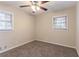 Neutral bedroom featuring two windows, plush carpet, neutral paint, and a ceiling fan at 2405 County Line Sw Rd, Atlanta, GA 30331