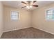 Neutral bedroom featuring two windows, plush carpet, neutral paint, and a ceiling fan at 2405 County Line Sw Rd, Atlanta, GA 30331