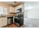 Well-lit kitchen with stainless steel appliances open to living area featuring hardwood floors and granite counters at 2405 County Line Sw Rd, Atlanta, GA 30331