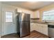 View of the kitchen showcasing modern stainless-steel appliances and a door to the backyard at 2405 County Line Sw Rd, Atlanta, GA 30331