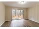 Open-plan living room with laminate flooring, large sliding glass doors, and view of trees at 2405 County Line Sw Rd, Atlanta, GA 30331