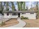 Charming single-story home featuring a black front door, white siding, and a welcoming walkway at 2529 Dale Creek Nw Dr, Atlanta, GA 30318