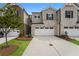 Two-story townhome with brick and siding exterior, two-car garage, and landscaping at 1247 Sunny Lake Dr, Lawrenceville, GA 30043