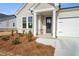 Inviting front porch with stone accents, a dark wood door and fresh landscaping at 1783 Juniper Berry Way, Loganville, GA 30052