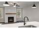 Kitchen island with sink and a view into the living room with fireplace at 1783 Juniper Berry Way, Loganville, GA 30052