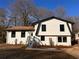Newly renovated home with a white exterior, black accents, and a manicured lawn at 2688 Heritage Ln, Morrow, GA 30260