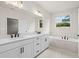 Double vanity bathroom with soaking tub and large mirror at 1682 Juniper Berry Way, Loganville, GA 30052