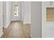 Bright hallway with light hardwood floors leading to a glass-paneled door and kitchen access at 1682 Juniper Berry Way, Loganville, GA 30052