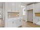 Kitchen with modern white cabinetry, gold backsplash, and ample counter space at 1682 Juniper Berry Way, Loganville, GA 30052