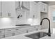 Kitchen sink and faucet with white cabinets and quartz countertops at 1682 Juniper Berry Way, Loganville, GA 30052