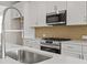 Modern kitchen equipped with stainless steel appliances, a gooseneck faucet, and tiled backsplash at 1682 Juniper Berry Way, Loganville, GA 30052