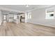 Bright living room featuring hardwood floors and an open layout to the kitchen with white cabinets at 1682 Juniper Berry Way, Loganville, GA 30052