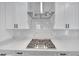 Stainless steel gas cooktop with white shaker cabinets and marble backsplash at 1862 Weatherbrook Cir, Lawrenceville, GA 30043