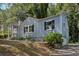 A quaint blue house with black shutters, a welcoming front porch, and lush greenery at 1626 Kenmore Sw St, Atlanta, GA 30311