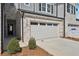 A two car garage with a concrete driveway and landscaping in front of the townhouse at 4178 Waratah Way, Mableton, GA 30126