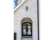 Elegant arched front door with black frame and glass panels, set in a white brick wall at 635 San Fernando Dr, Smyrna, GA 30080