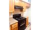 Black stove and range in kitchen with wood cabinets at 79 Place Fontaine, Lithonia, GA 30038