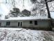 Back of house showing a light gray exterior, sliding glass doors and a snow covered yard at 1783 Nicole Ln, Lithonia, GA 30058