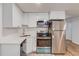 Modern galley kitchen featuring stainless steel appliances and white cabinetry at 3640 Rolling Creek Dr, Buford, GA 30519