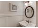 Charming half bathroom with pedestal sink, decorative mirror, and wainscoting at 3640 Rolling Creek Dr, Buford, GA 30519