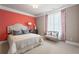 Bright bedroom with coral accent wall, comfortable bed, and sitting area at 4983 Kyle Dr, Powder Springs, GA 30127