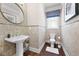 Small powder room with pedestal sink and mosaic tile at 4983 Kyle Dr, Powder Springs, GA 30127