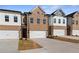 Three-story townhouses with brick and white siding, two-car garages, and landscaping at 883 Eagle Ave, Riverdale, GA 30274