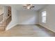 Bright living room featuring luxury vinyl flooring, large window, ceiling fan, and staircase at 883 Eagle Ave, Riverdale, GA 30274