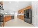 Kitchen with oak cabinets, black appliances, and tile flooring at 127 Ennisbrook Se Dr, Smyrna, GA 30082