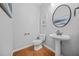 Stylish powder room with pedestal sink and wood flooring at 127 Ennisbrook Se Dr, Smyrna, GA 30082