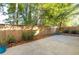 Private backyard with a concrete patio, wooden fence, and mature trees at 230 Ascott Ln, Woodstock, GA 30189