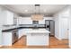 Kitchen boasts white cabinets, granite counters, and island at 230 Ascott Ln, Woodstock, GA 30189