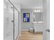 Modern bathroom featuring a glass-enclosed shower, white vanity, contemporary artwork, and neutral color palette at 8218 Tiger Way, Riverdale, GA 30296