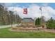 Stone sign welcomes to Auburn Ridge, accented by flowers and American flags at 8218 Tiger Way, Riverdale, GA 30296