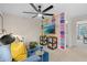 Modern living room with a ceiling fan, blue couch, colorful wall art, and open doorway to another room at 8218 Tiger Way, Riverdale, GA 30296