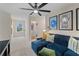 Upstairs living room with a comfortable blue couch, laundry room access, and stylish decorations on the wall at 8218 Tiger Way, Riverdale, GA 30296