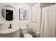 A well-lit bathroom featuring a white sink, toilet, and shower at 123 Hollow Springs Dr, Hiram, GA 30141